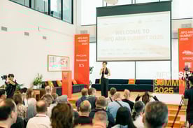 Speaker presenting at NFQ Asia Summit 2025 in front of a seated audience.