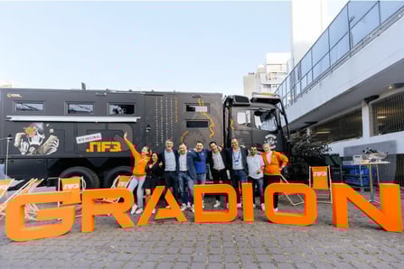 Gradion team posing at a major event in Germany with branded truck and logo.